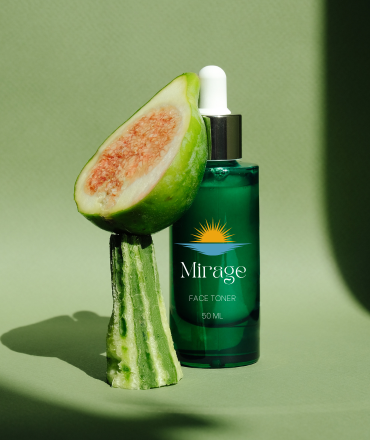 A bottle of Mirage face toner with a dropper and half a fig on green background.